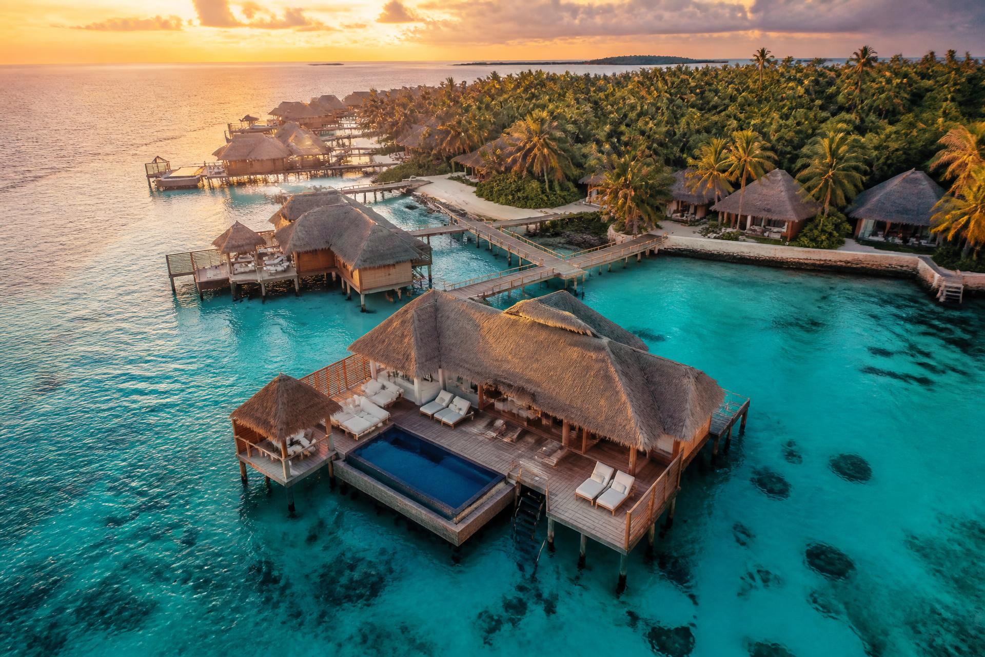 Overwater villas and a private pool above a turquoise Maldives lagoon